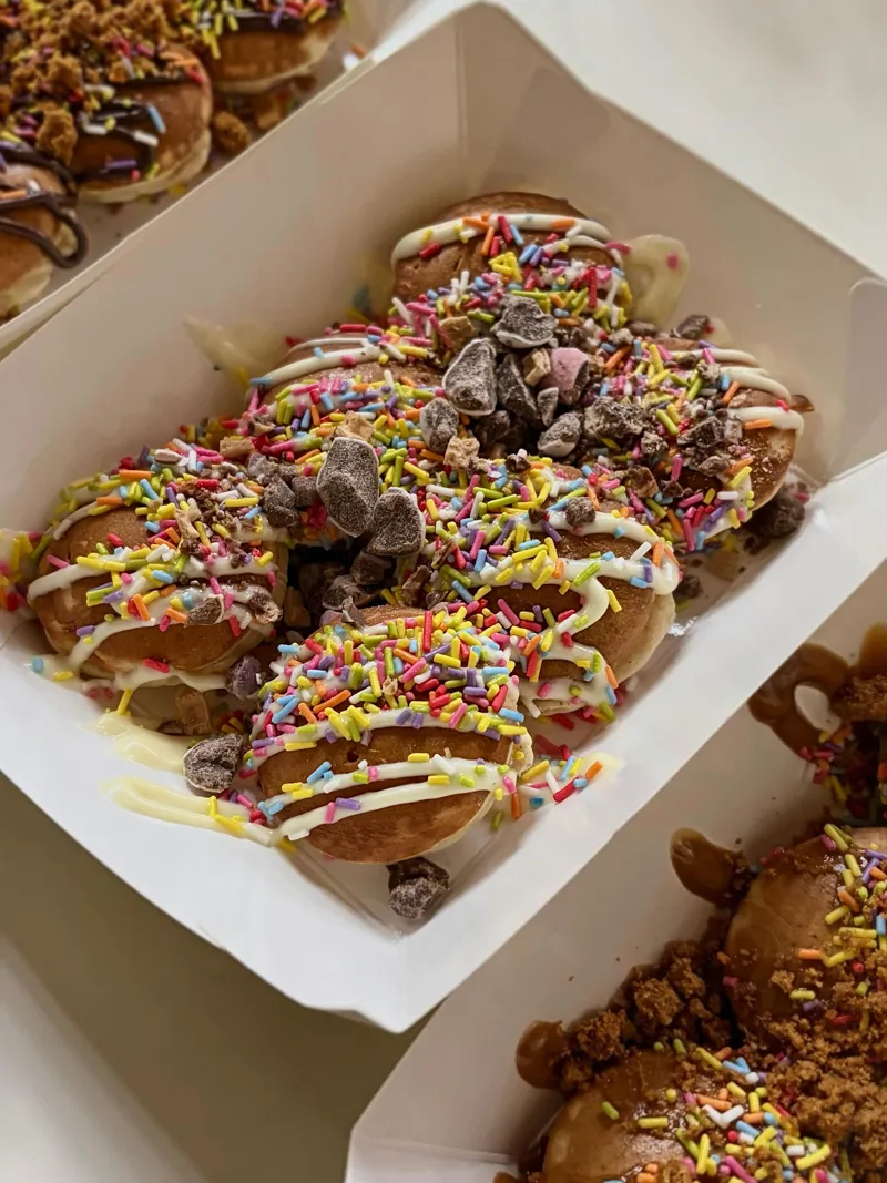 Trays of mini pancakes with chocolate drizzle and sprinkles